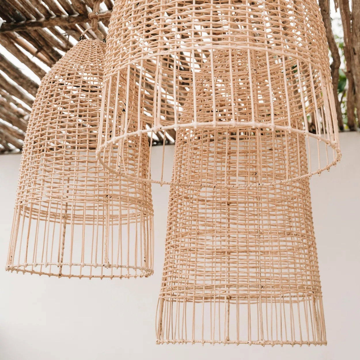 Woven rattan pendant lights against a neutral background